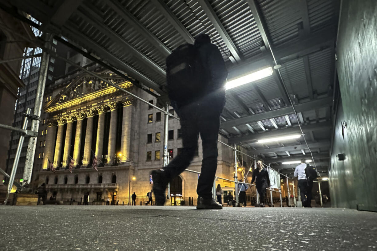 FILE - People walk under a sidewalk shed near the New York Stock Exchange on Oct. 30, 2024.