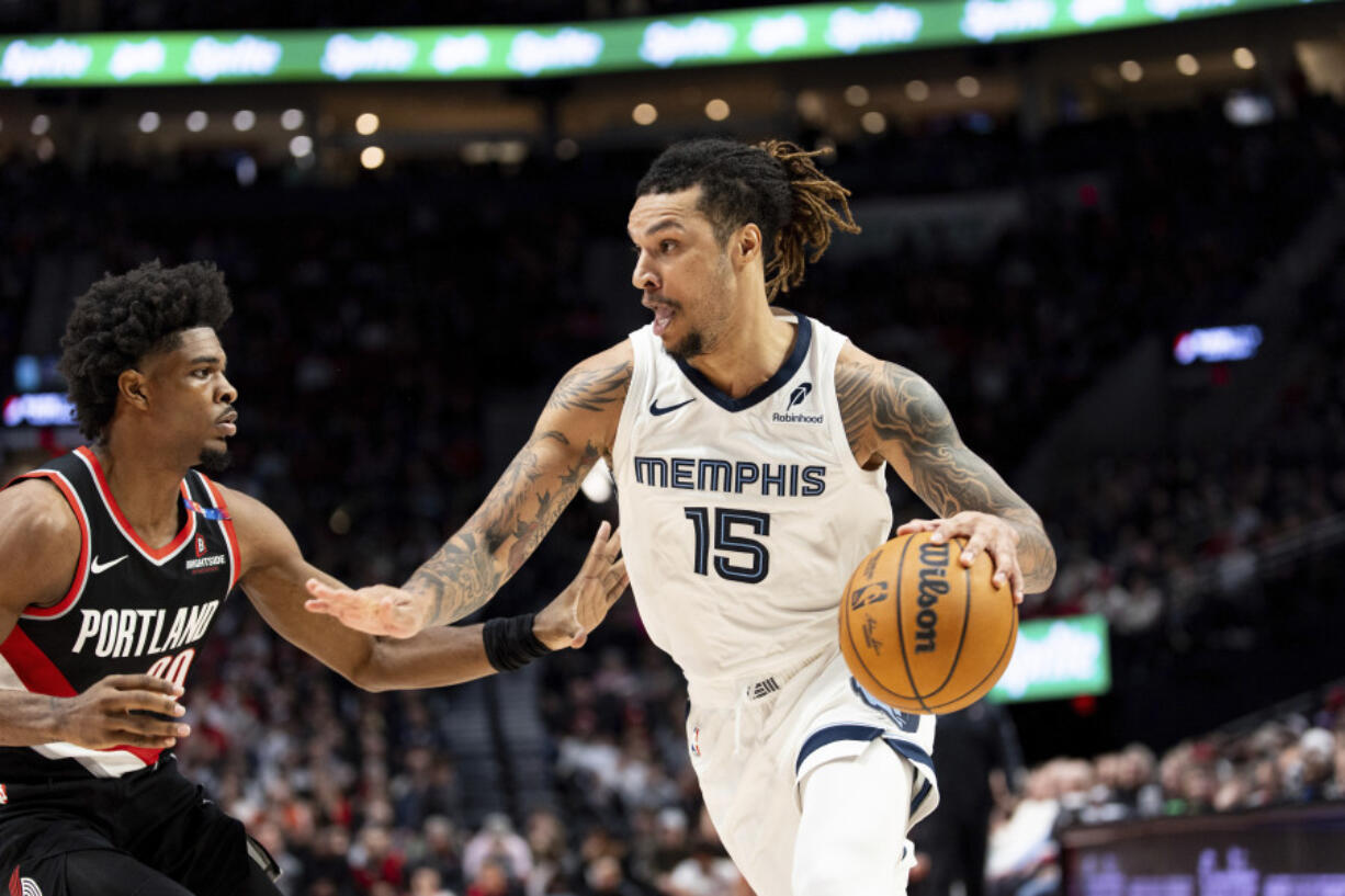 Memphis Grizzlies forward Brandon Clarke, right, drives to the hoop against Portland Trail Blazers guard Scoot Henderson, left, during the second half of an NBA basketball game Sunday, Nov. 10, 2024, in Portland, Ore.