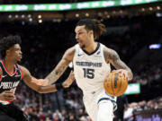 Memphis Grizzlies forward Brandon Clarke, right, drives to the hoop against Portland Trail Blazers guard Scoot Henderson, left, during the second half of an NBA basketball game Sunday, Nov. 10, 2024, in Portland, Ore.