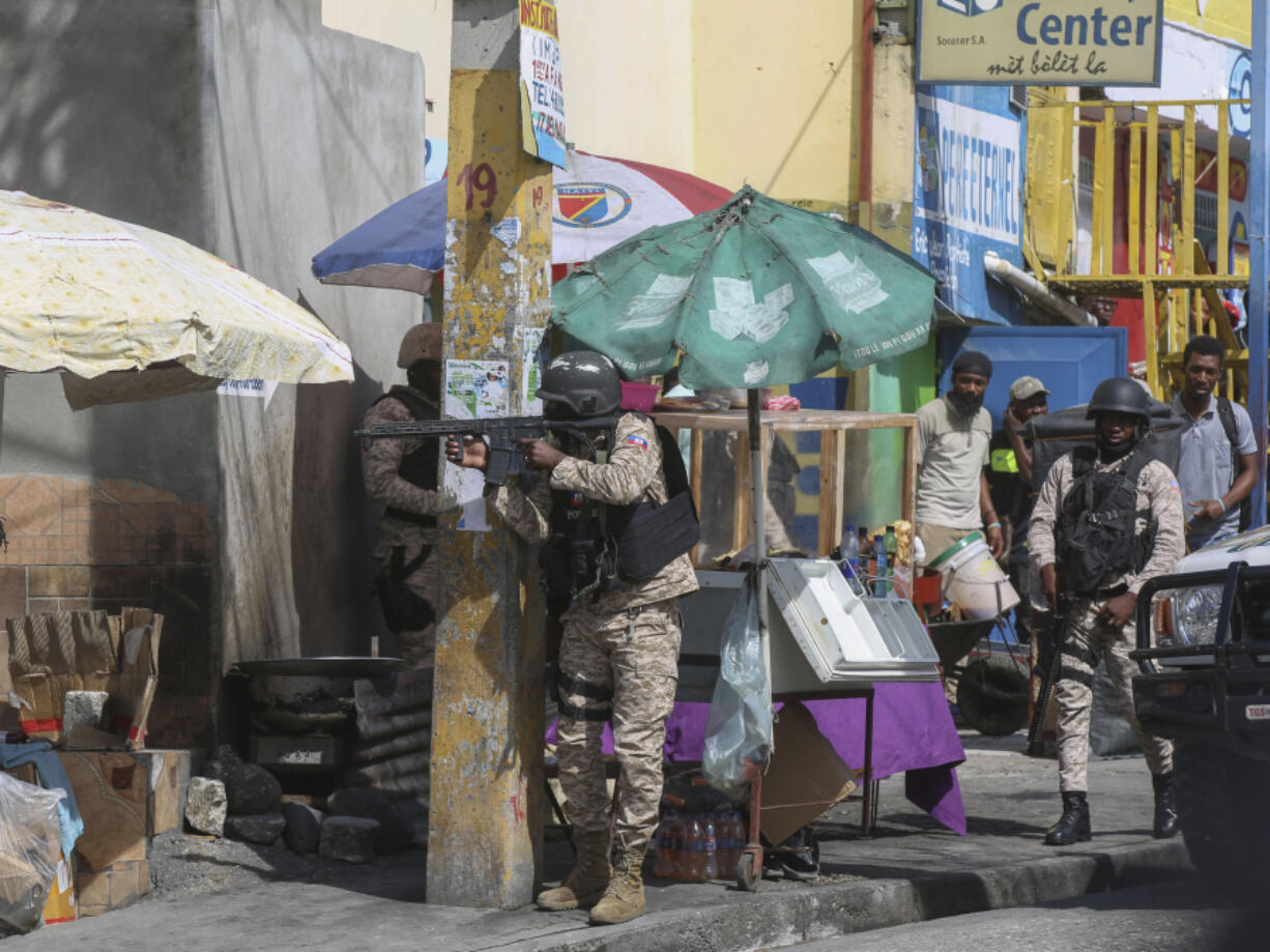 Police officers patrol a street during an exchange of gunfire between gangs and police in Port-au-Prince, Haiti, Monday, Nov. 11, 2024.