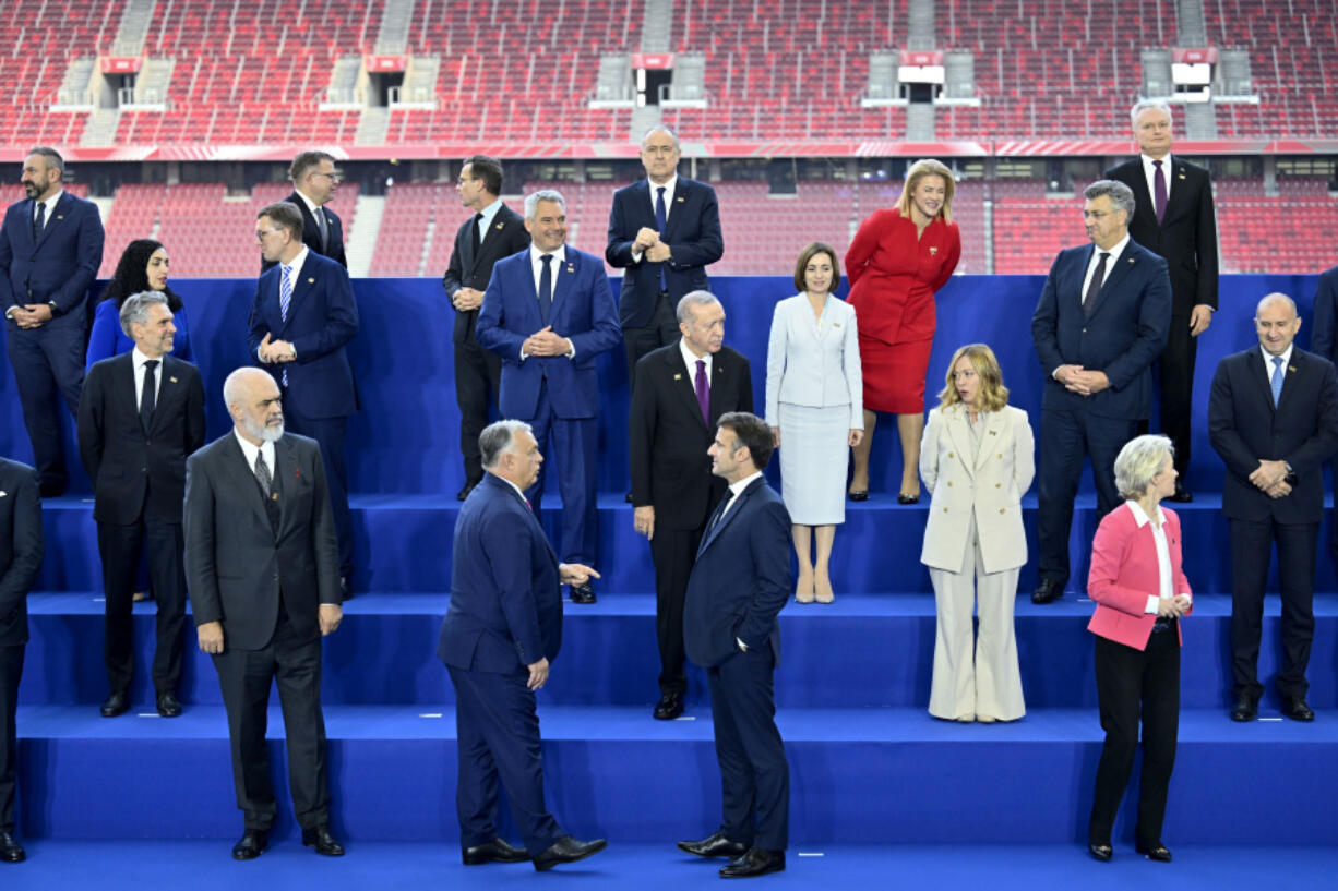 Hungary&rsquo;s Prime Minister Viktor Orban, center left front, speaks with French President Emmanuel Macron as other leaders pose during a group photo during the European Political Community (EPC) Summit at the Puskas Arena in Budapest, Thursday, Nov. 7, 2024.