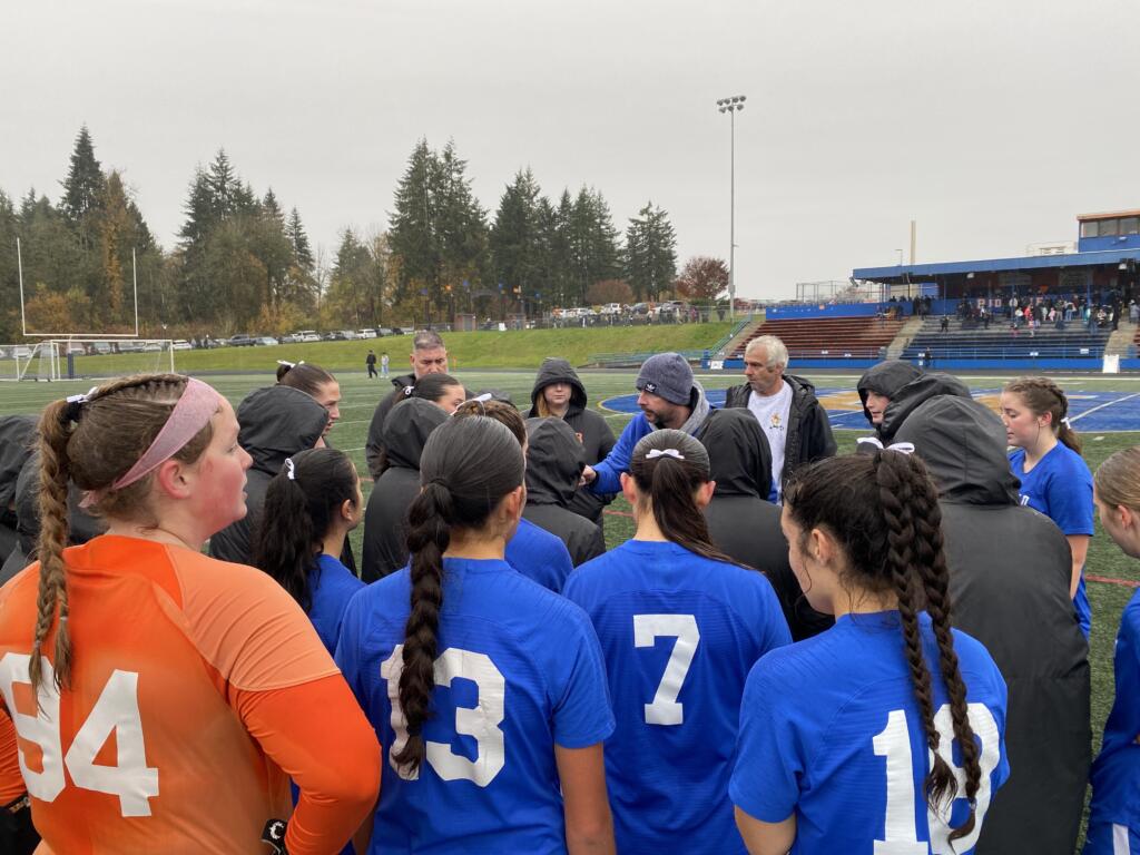 Head coach Steven Evans (facing, in grey hat) chats with the Ridgefield Spudders after their 5-0 shutout of Fife in Saturday's 2A girls soccer state quarterfinal game. The defending 2A state champion Spudders advance to their third state semifinal in four years and face Bellingham on Friday in Tacoma.