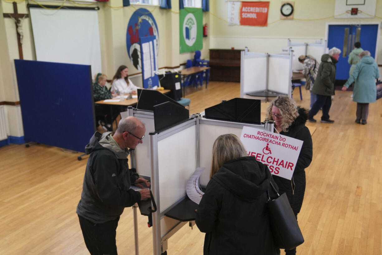 People cast their votes at Greenmount National School in Cork, as voters go to polls the for the 2024 General Election in Ireland, Friday, Nov. 29, 2024.