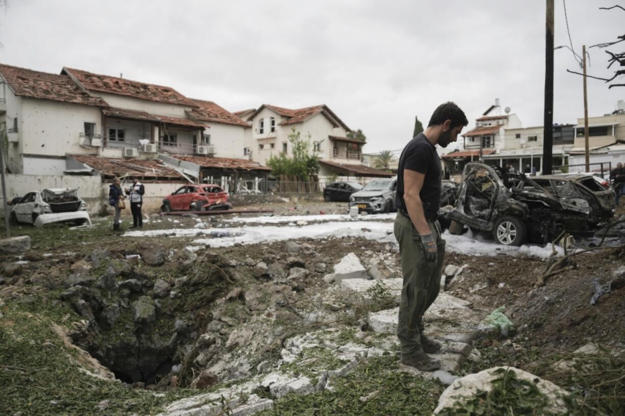 Israeli police bomb squad members inspect the site where a missile fired from Lebanon hit Petah Tikva, on the outskirts of Tel Aviv, Israel, on Sunday.