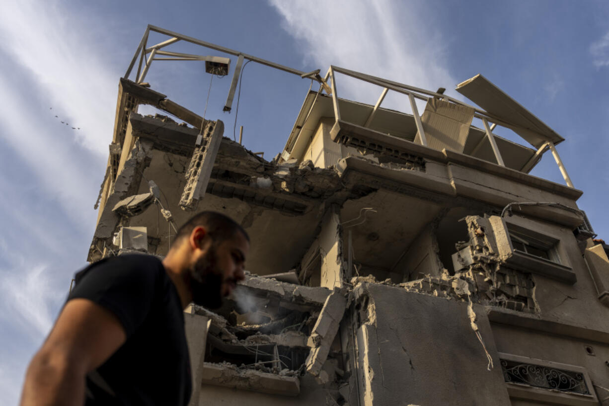 A man surveys damage to a building where emergency service said 11 people were hurt by shrapnel and glass shards in a direct strike by projectiles fired from Lebanon after it hit a home in Tira, central Israel, Saturday, Nov. 2, 2024.