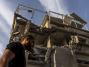 A man surveys damage to a building where emergency service said 11 people were hurt by shrapnel and glass shards in a direct strike by projectiles fired from Lebanon after it hit a home in Tira, central Israel, Saturday, Nov. 2, 2024.