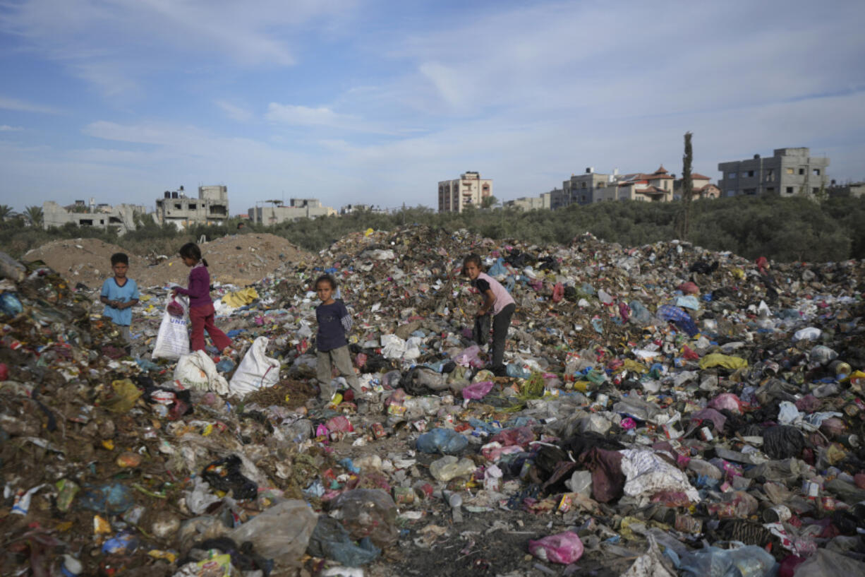 Palestinian kids sort through trash at a landfill in Zawaida, Gaza Strip, Sunday, Nov. 17, 2024.