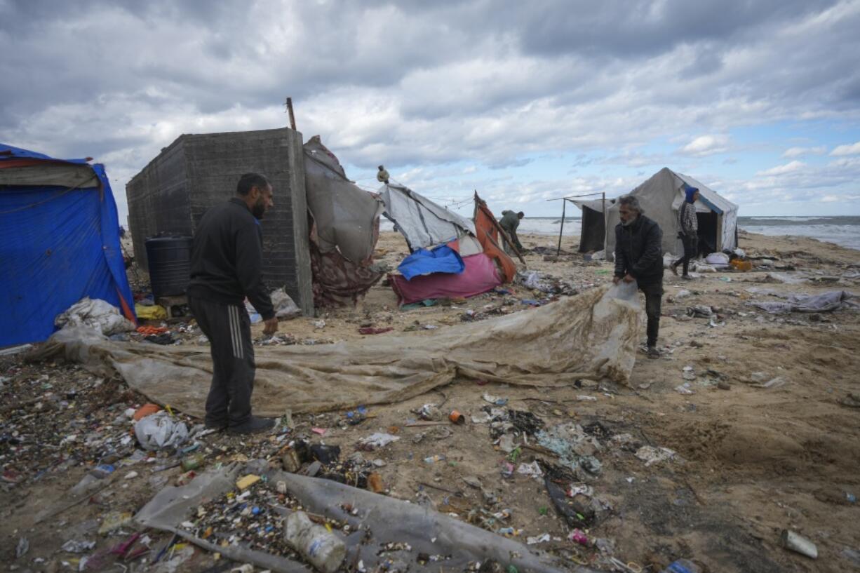 Palestinians fix a tent at a camp for displaced residents on the beach front in Deir al-Balah, Gaza Strip, Tuesday Nov. 26, 2024.