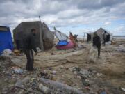 Palestinians fix a tent at a camp for displaced residents on the beach front in Deir al-Balah, Gaza Strip, Tuesday Nov. 26, 2024.