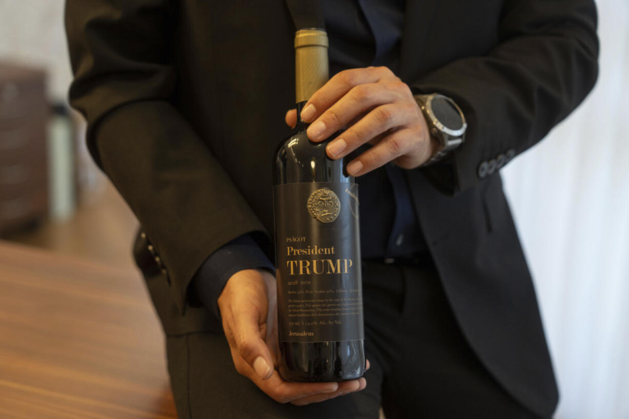 Israel Ganz, chairman of the Yesha settlers council and head of the Mateh Binyamin Regional Council, poses for a portrait holding a bottle of wine bearing the name of U.S. President-elect Donald Trump in the Shaar Binyamin Industrial Park in the West Bank, Monday, Nov. 11, 2024.