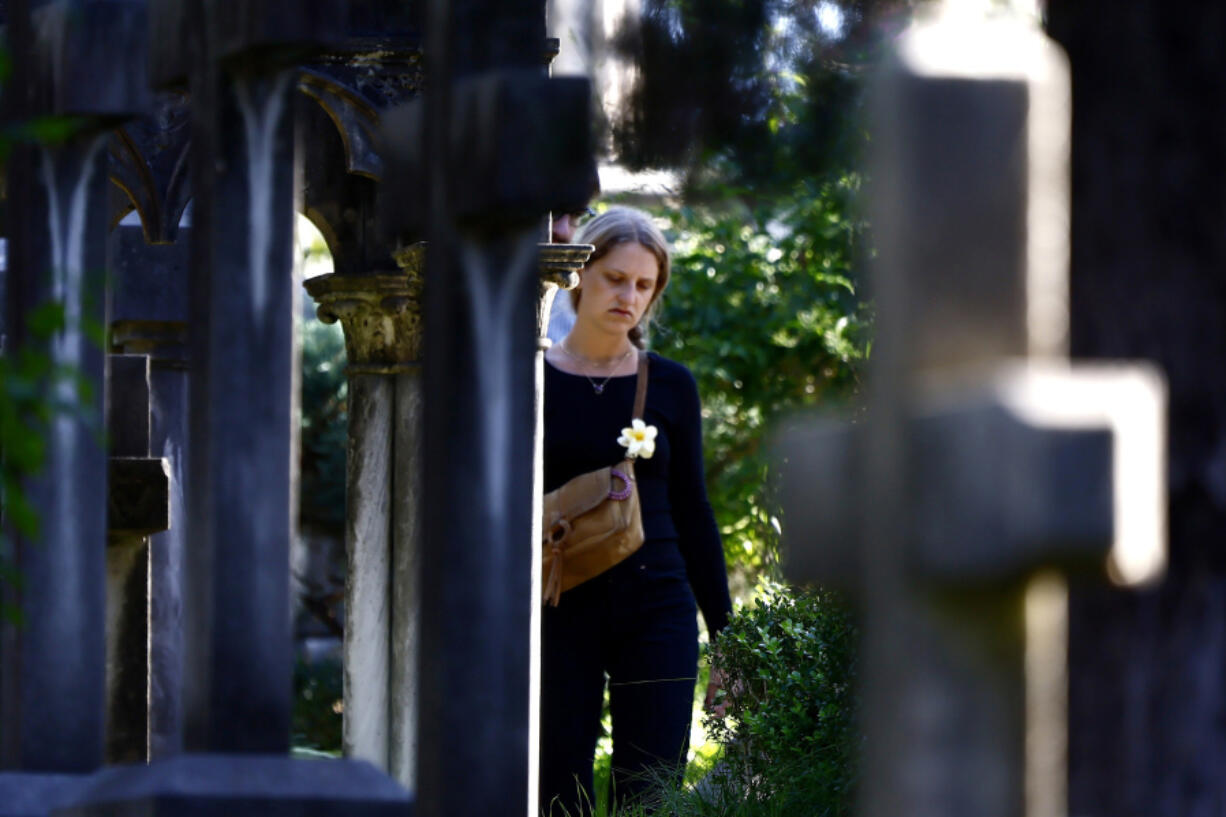 A woman walks in a cemetery on the occasion of All Saints Day, in Rome, Friday, Nov. 1, 2024.