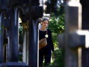 A woman walks in a cemetery on the occasion of All Saints Day, in Rome, Friday, Nov. 1, 2024.