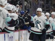 Seattle Kraken center Matty Beniers celebrates a goal against the Colorado Avalanche with teammates on the bench during the third period of an NHL hockey game Tuesday, Nov. 5, 2024, in Denver.