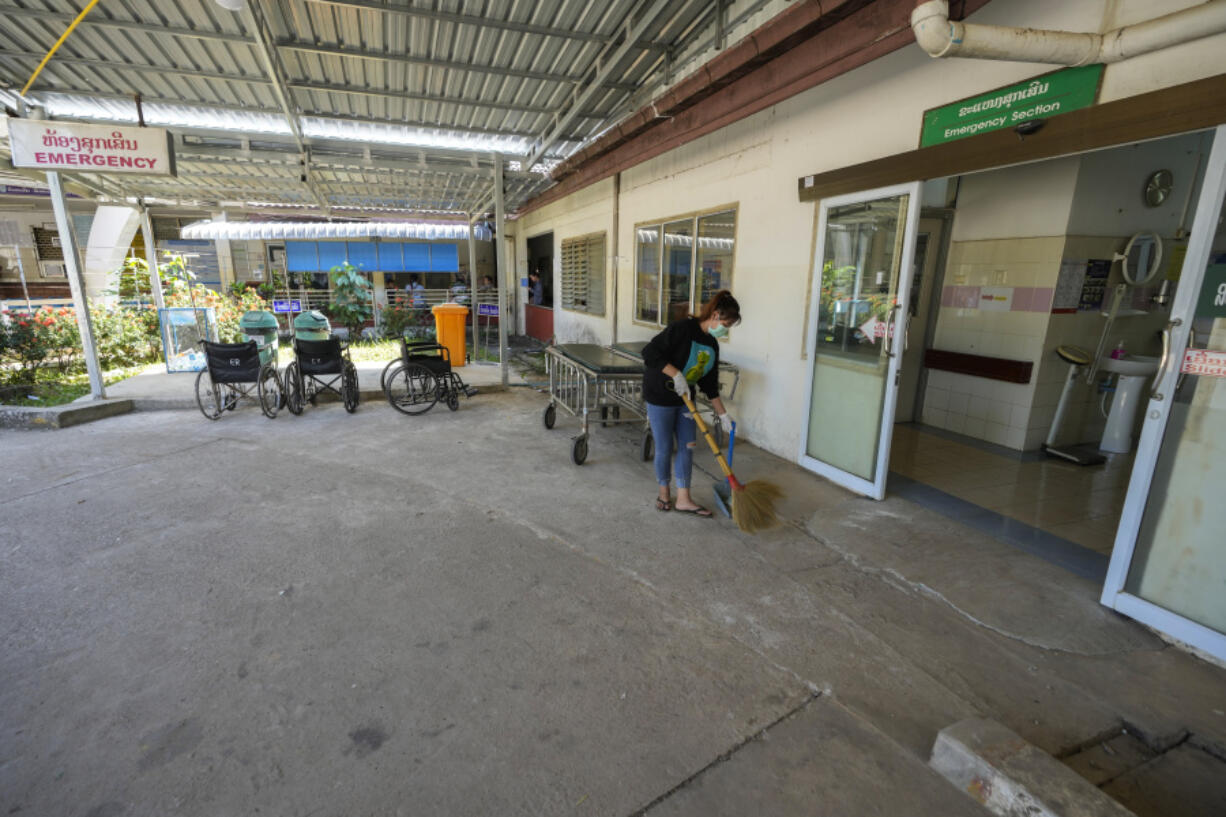 A woman cleans near the emergency section of a hospital where poisoned foreign tourists admitted in Vang Vieng, Laos, Friday, Nov. 22, 2024.