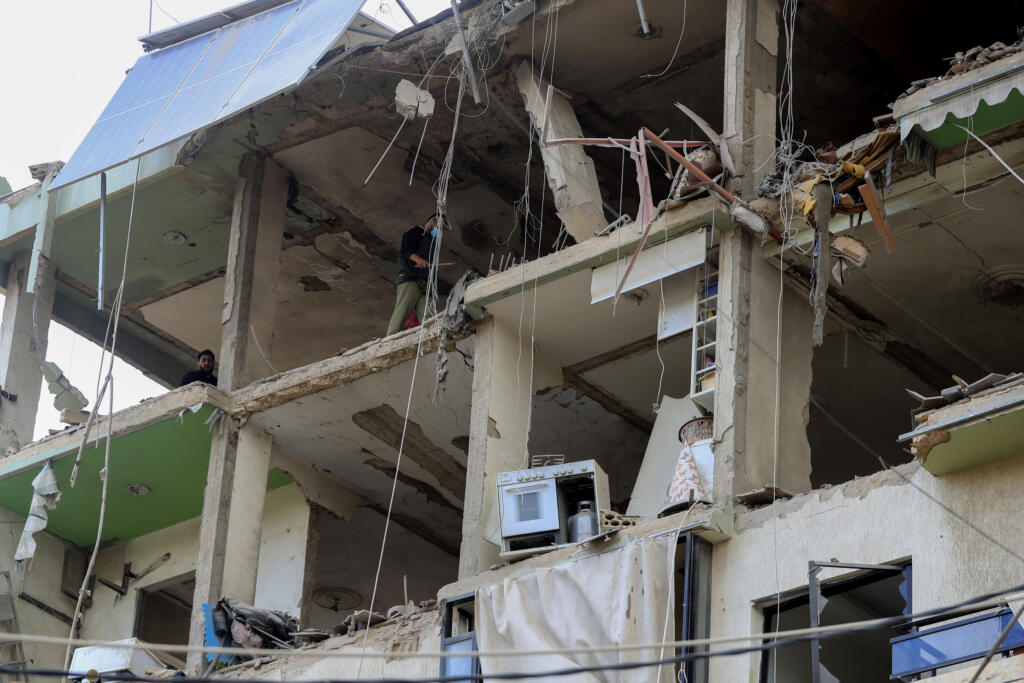 People inspect a destroyed building hit in an Israeli airstrike, in the southern port city of Sidon, Lebanon, Sunday, Nov. 3, 2024.