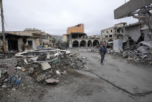 A man walks in a destroyed neighborhood, in the town of Bint Jbeil, southern Lebanon, following a ceasefire between Israel and Hezbollah that went into effect on Wednesday, Nov. 27, 2024.