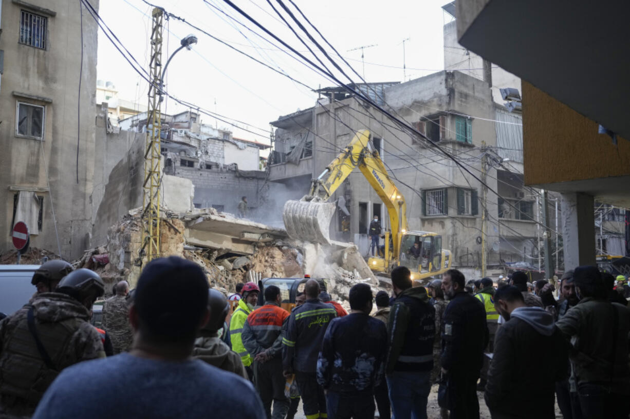 Rescuers use an excavator as they search for victims at the site of an Israeli airstrike that targeted a building in Beirut, Lebanon, Tuesday, Nov. 26, 2024.