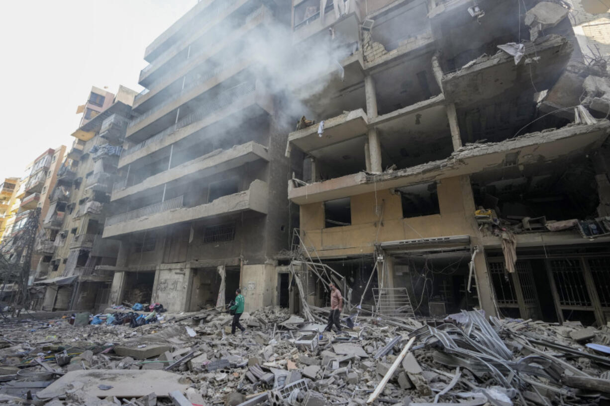 Residents check the site of an Israeli airstrike in Dahiyeh, Beirut, Lebanon , Saturday, Nov. 9, 2024.