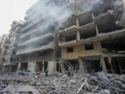 Residents check the site of an Israeli airstrike in Dahiyeh, Beirut, Lebanon , Saturday, Nov. 9, 2024.