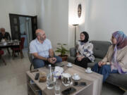 Members of a displaced family, who fled from an Israeli airstrike in Mhaibib, a Lebanese border village with Israel, share memories of their village as they sit in their house in Aramoun village, southeast of Beirut, Lebanon, Saturday, Oct. 26, 2024.