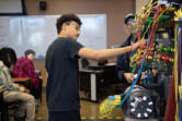 Simon Jones, 14, of iUrban Teen, center, gets hands-on experience during a tour of the Clark College electrical and power distribution systems lab April 1. Vancouver nonprofit iUrban Teen supports local youth of color through STEM education and the arts. It was recently awarded $847,208 as part of the Oregon Workforce Ready Grant initiative.