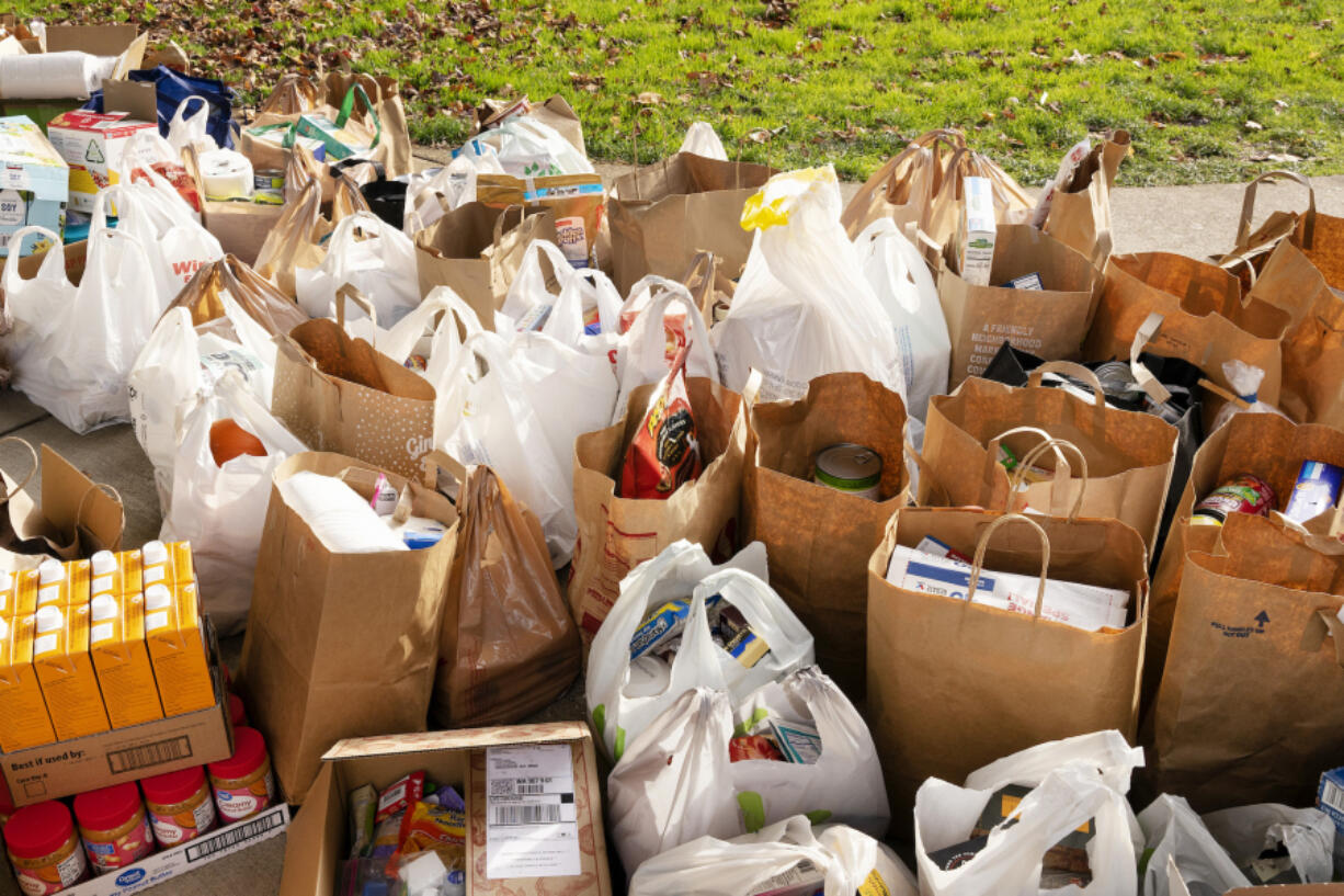 Bags of donated food and goods wait to be organized by Walk &amp; Knock volunteers during the December 2022 food drive.