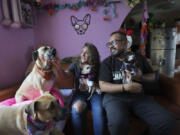 Meztli Lizaola and V&iacute;ctor Sorchaga sit with their pets on Oct. 30 in their home in Mexico City.