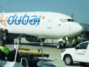 Workers prepare a FlyDubai flight at Dubai International Airport in Dubai, United Arab Emirates, Friday, Oct. 18, 2024.