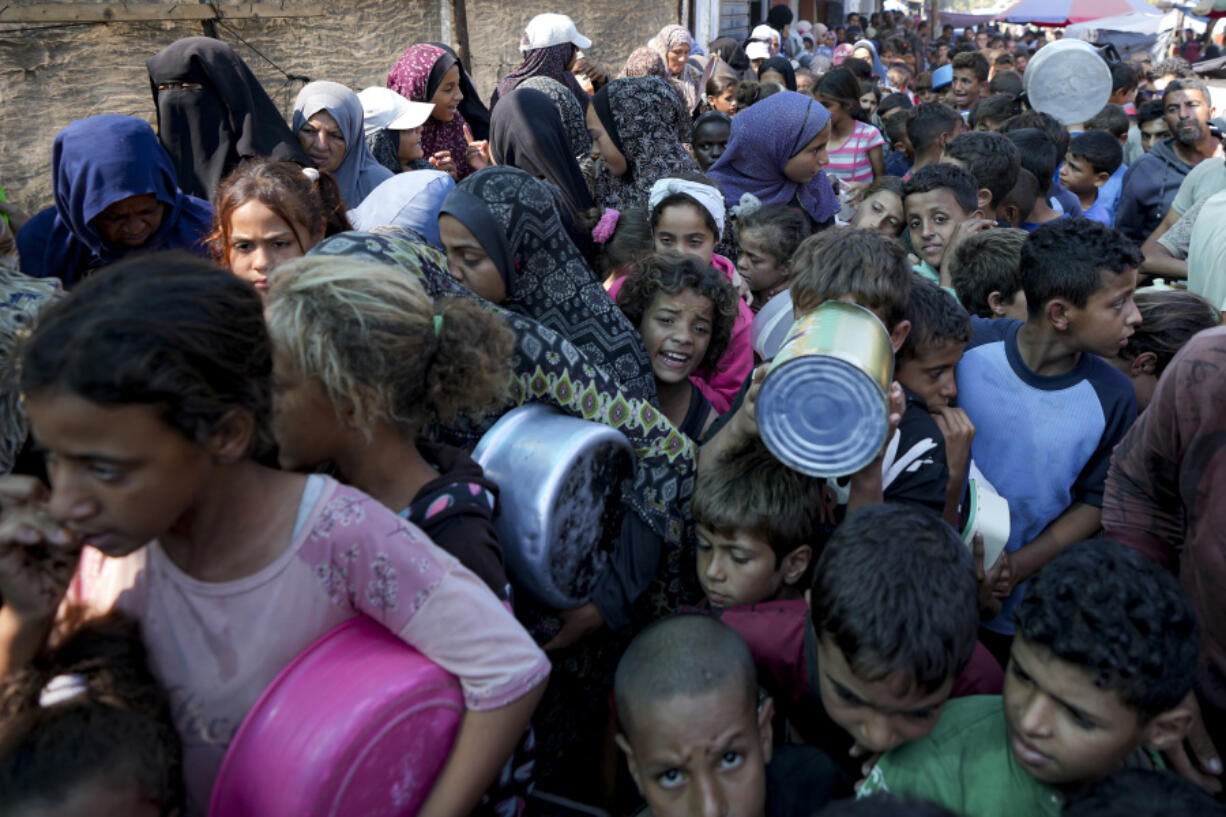 FILE - Palestinians line up for food distribution in Deir al-Balah, Gaza Strip, on Oct. 17, 2024.