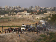 FILE - Palestinians are storming trucks loaded with humanitarian aid brought in through a new U.S.-built pier, in the central Gaza Strip, on May 18, 2024.