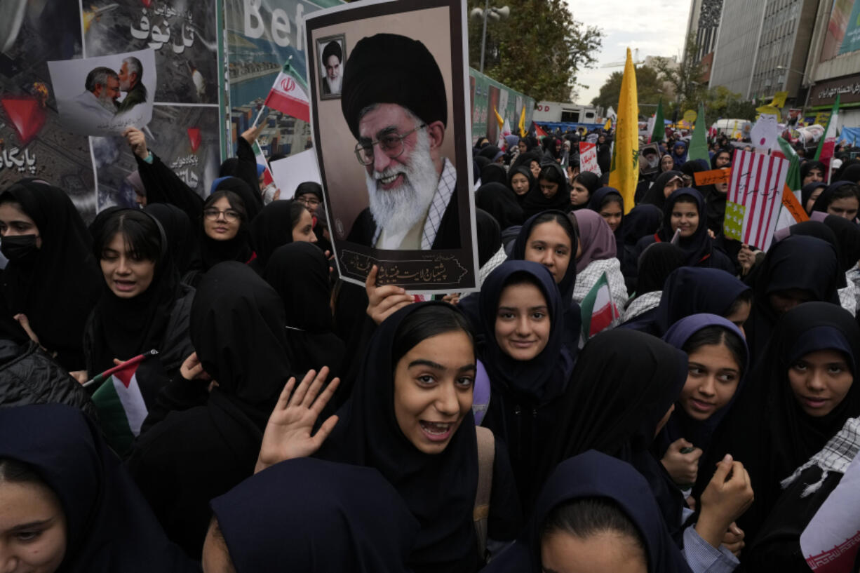 Holding a poster of Iranian Supreme Leader Ayatollah Ali Khamenei, students attend a rally Sunday in front of the former U.S. Embassy in Tehran, Iran, marking the 45th anniversary of Iranian students&rsquo; takeover of the embassy.