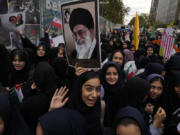 Holding a poster of Iranian Supreme Leader Ayatollah Ali Khamenei, students attend a rally Sunday in front of the former U.S. Embassy in Tehran, Iran, marking the 45th anniversary of Iranian students&rsquo; takeover of the embassy.