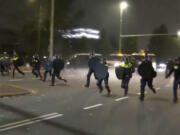 In this image taken from video, police in riot gear run towards protesters, after pro-Palestinian supporters marched near the soccer stadium, in Amsterdam, Netherlands, Thursday, Nov. 7, 2024.