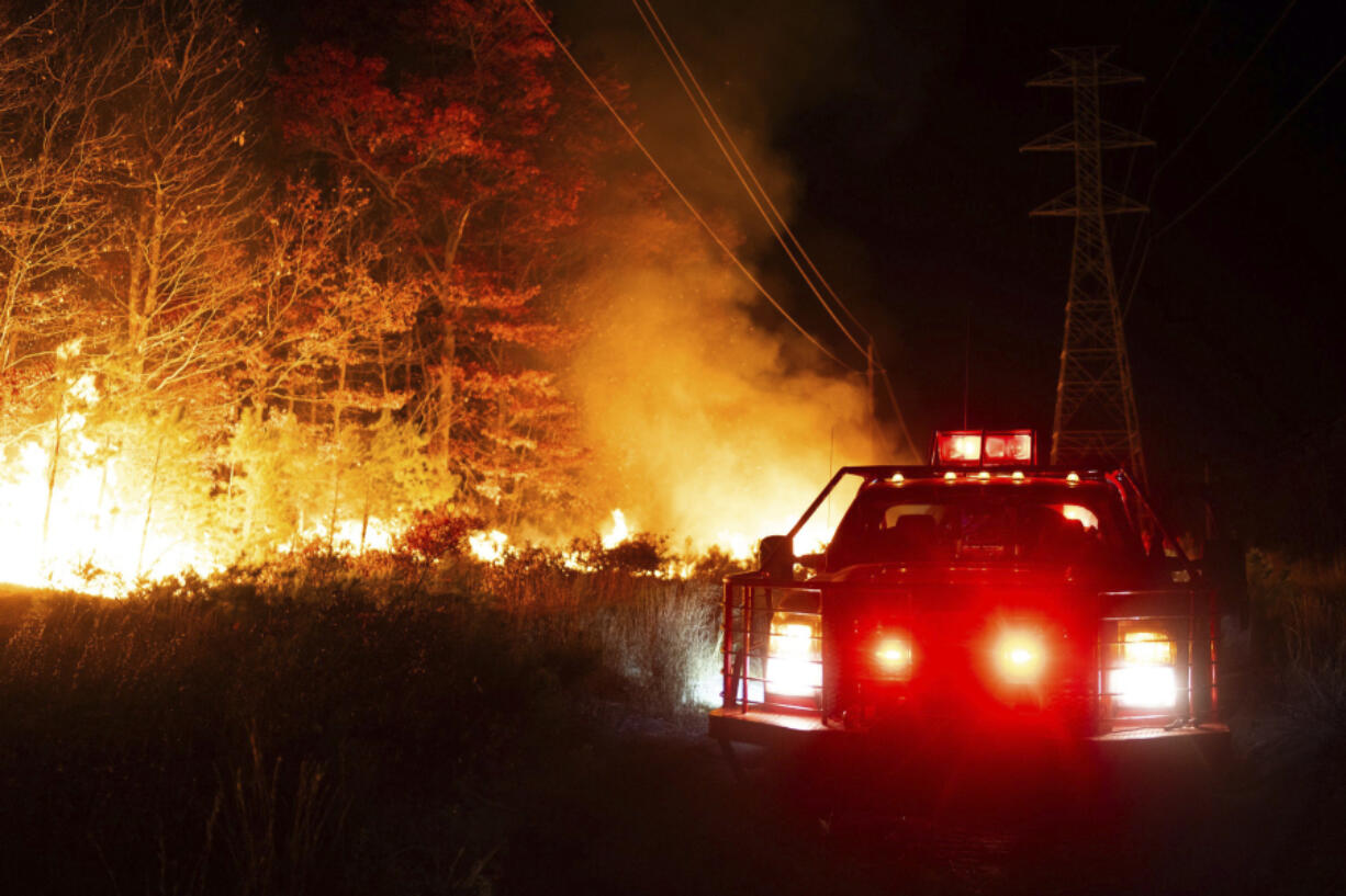 This photo provided by New Jersey Department of Environmental Protection firefighters respond to a forest fire on Wednesday, Nov. 6, 2024 in Evesham, N.J.