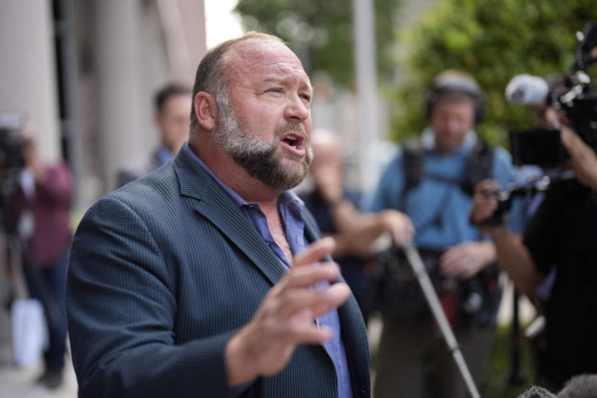 FILE - Right-wing conspiracy theorist Alex Jones speaks to the media after arriving at the federal courthouse for a hearing in front of a bankruptcy judge, Friday, June 14, 2024, in Houston.  (AP Photo/David J.