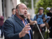 FILE - Right-wing conspiracy theorist Alex Jones speaks to the media after arriving at the federal courthouse for a hearing in front of a bankruptcy judge, Friday, June 14, 2024, in Houston.  (AP Photo/David J.