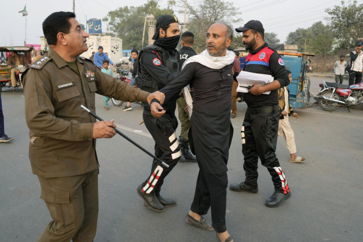 Police officers detain a supporter of imprisoned former Premier Imran Khan&rsquo;s Pakistan Tehreek-e-Insaf party Sunday in Lahore, Pakistan. (K.M.