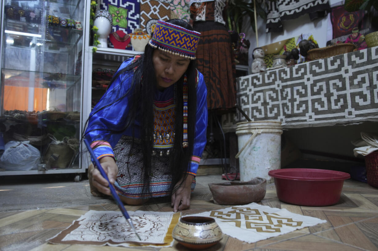 Sadith Silvano, from Paoyhan, a Shipibo-Konibo Indigenous community in the Amazon, paints a tablecloth at her home and workshop in Lima, Peru, Saturday, Oct. 19, 2024. Handpainted textiles like the ones she crafts, known as &ldquo;ken&eacute;,&rdquo; have slowly gained recognition and were declared part of the &ldquo;Cultural Heritage of the Nation&rdquo; by the Peruvian government in 2008.