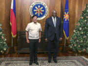 U.S. Defense Secretary Lloyd Austin, right, and Philippine President Ferdinand Marcos Jr. pose for a photograph during a courtesy call at the Malacanang Palace in Manila, Philippines Monday, Nov. 18, 2024.