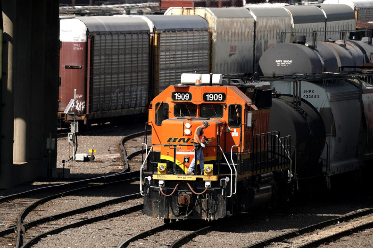 FILE - A worker boards a locomotive at a BNSF rail yard, Sept. 14, 2022, in Kansas City, Kan.