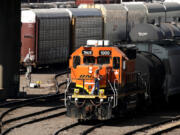 FILE - A worker boards a locomotive at a BNSF rail yard, Sept. 14, 2022, in Kansas City, Kan.