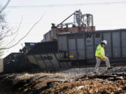 FILE - A Norfolk Southern worker walks next to the scene of a multi-car coal train derailment near Suffolk, Va., on Feb. 4, 2017.