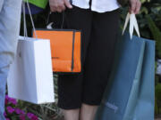 FILE - Shoppers hold bags after shopping in Bradenton, Fla., Feb. 9, 2024. (AP Photo/Gene J. Puskar.