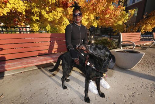 Amber Sherrard and her 10-year-old black Labrador Della are shown outside their home Friday, Nov. 15, 2024, in east Denver.