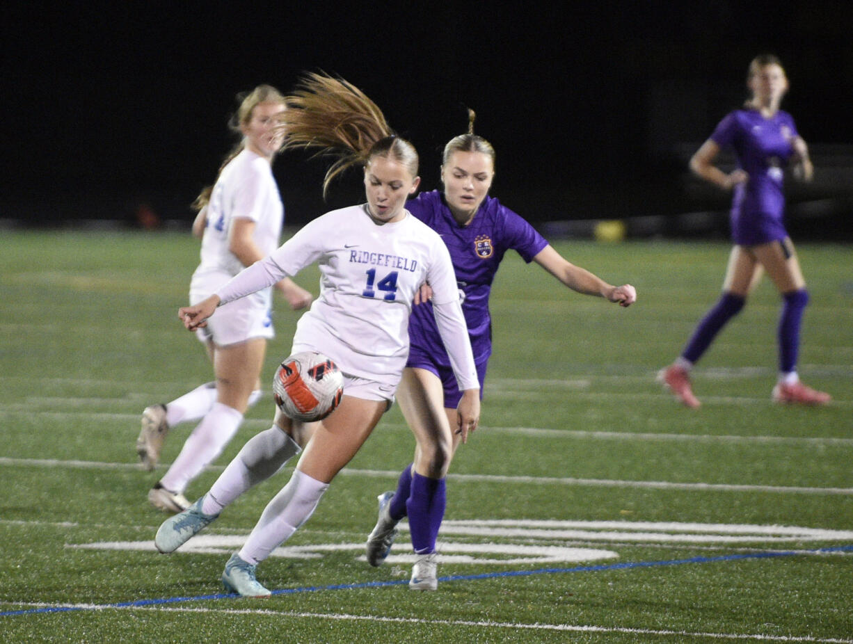 Ridgefield's Ellie Wilson (14) looks to settle the ball against Columbia River's Julia Rapp during the Class 2A District 4 girls soccer championship game on Saturday, Nov. 9, 2024, at Columbia River High School.