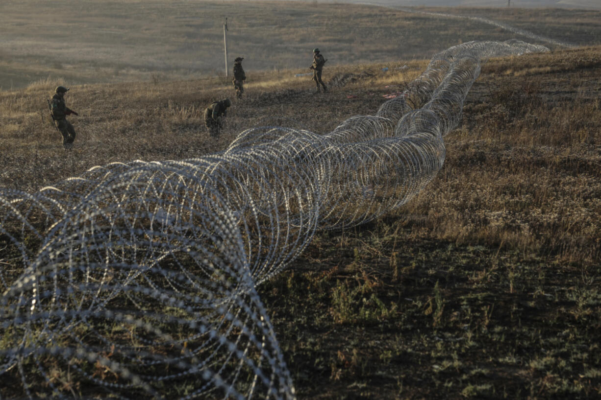 In this photo provided by Ukraine&rsquo;s 24th Mechanised Brigade press service, servicemen of the 24th Mechanised Brigade install anti-tank landmines and non explosive obstacles along the front line near Chasiv Yar town in Donetsk region, Ukraine, Wednesday Oct. 30, 2024.