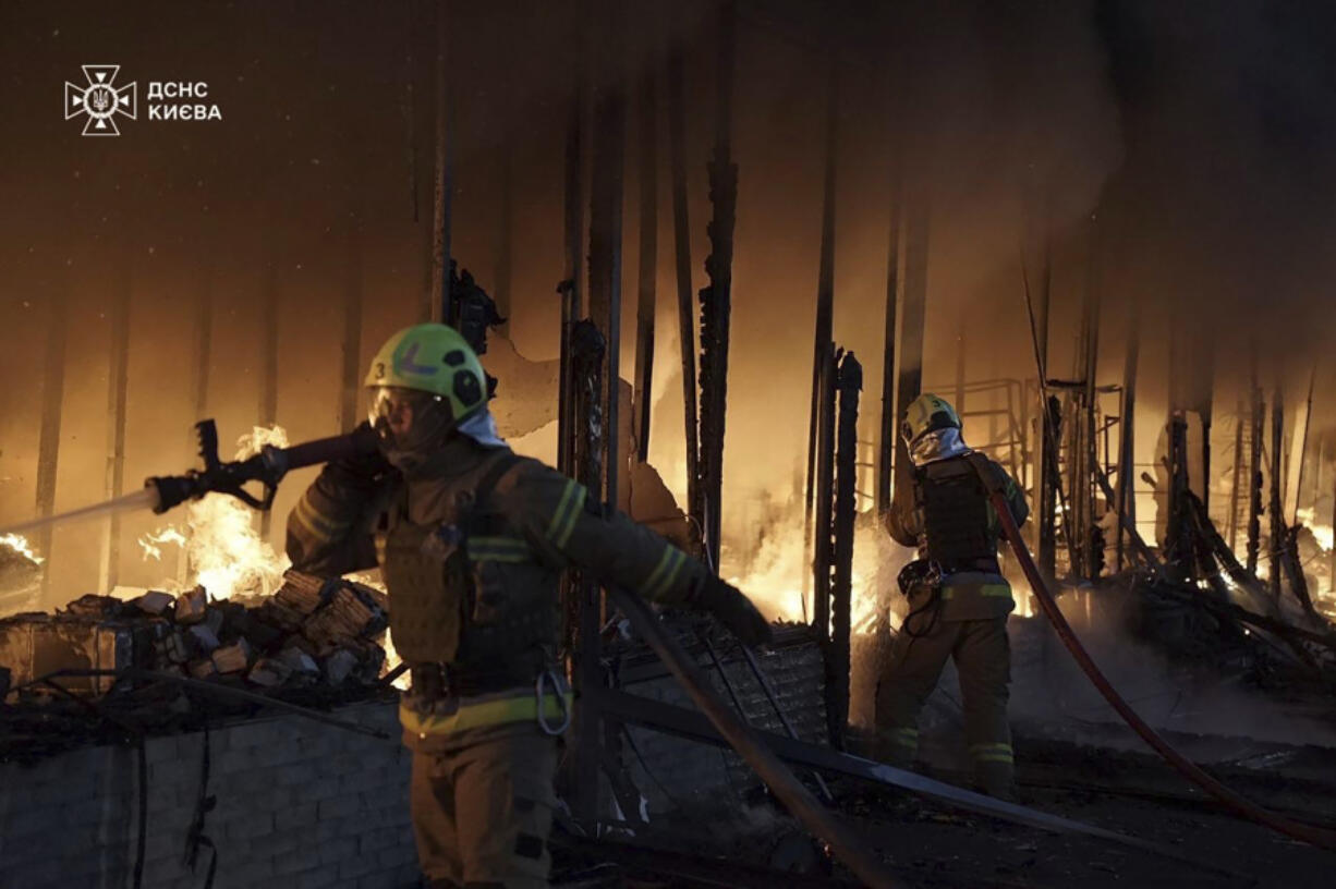 In this photo provided by the Ukrainian Emergency Service on Thursday, Nov. 7, 2024, rescuers put out a fire of a building which was resulted from Russian drone attack in Kyiv, Ukraine.