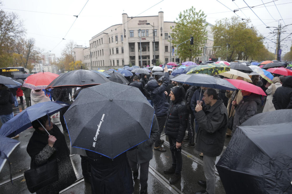 People stopping traffic and standing in silence to commemorate the 15 victims of a railway roof collapse two weeks ago, demand accountability for the tragedy, in Belgrade, Serbia, Friday, Nov. 22, 2024.