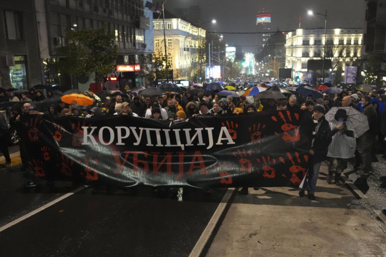 People march during a protest following the collapse of a concrete canopy at the railway station in Novi Sad that killed 14 people, in Belgrade, Serbia, Monday, Nov. 11, 2024.