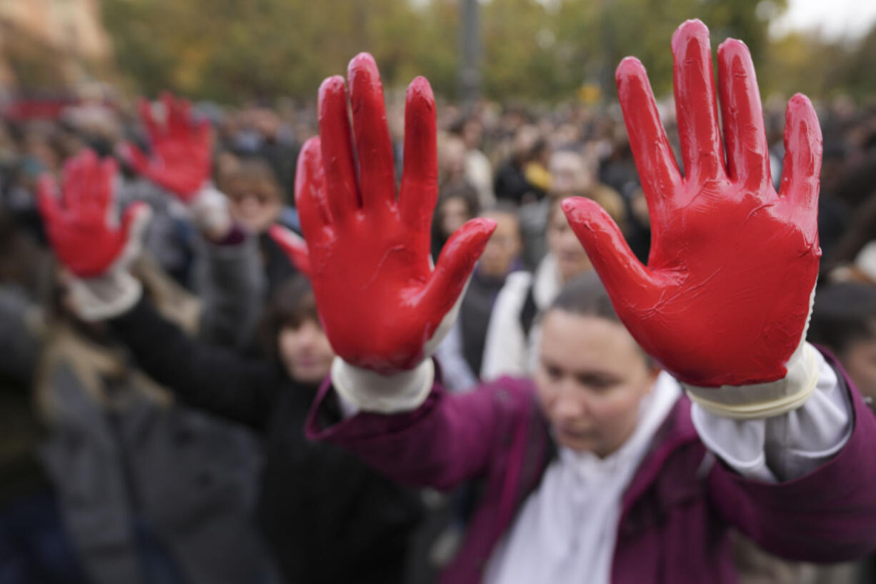 Protesters shout slogans with red paint on the hands symbolizing blood, demand arrests, two days after a concrete canopy collapsed at a railway station in Novi Sad, killing 14 people and injuring three, during protest in Belgrade, Serbia, Sunday, Nov. 3, 2024.